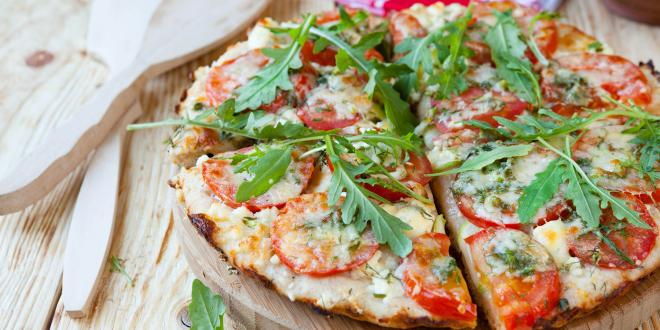Small homemade pizza on a wooden plate